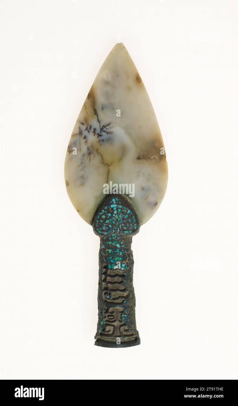 Tête de lance cérémonielle mao, 1600-1046 av. J.-C., 6 9/16 × 2 1/4 × 11/16 po., 0,2 lb. (16,67 × 5,72 × 1,75 cm, 0,1 kg)1 × 11/16 po. (2,54 × 1,75 cm) (partie objet, ouverture inférieure), jade blanc grisâtre avec variations de nuages bleuâtres et bruns, bronze avec incrustation de cristal vert, Chine, fin de la dynastie Shang, Une tête de lance en bronze fixée à un long poteau aurait servi d'arme dans le combat au corps à corps. Cet exemple, composé d'une lame de jade et d'une poignée de bronze, était beaucoup plus rare et n'aurait eu qu'une fonction cérémonielle. La lance de jade a une arête centrale créant une surface biseautée Banque D'Images