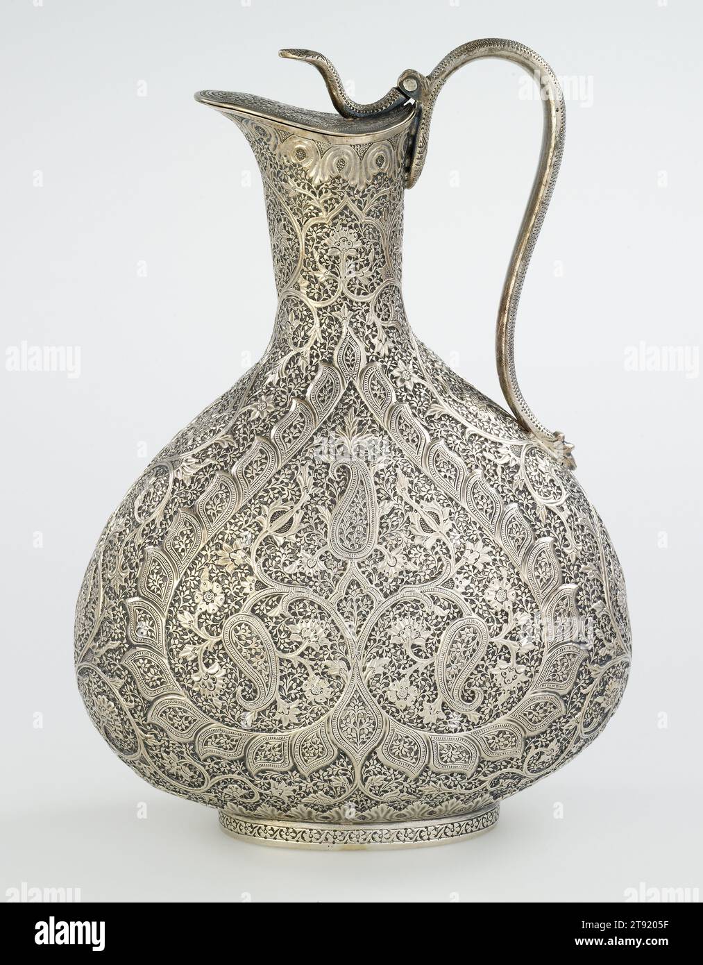 Carafe Claret, c. 1890, 9 1/4 x 6 3/4 x 4 po. (23,5 x 17,15 x 10,16 cm), argent, Inde, 19e siècle, cette cruche très embellie pour Claret, un vin rouge français, témoigne d'une esthétique anglo-indienne. Ce style s'est avéré à la mode parmi les officiers britanniques basés sur le sous-continent, les Indiens anglophiles, ainsi que les marchés à l'étranger. Le motif central de la cruche présente un arbre qui pousse trois mangues allongées, une forme connue sur le sous-continent sous le nom de kunj. En Europe, ce motif est mieux connu sous le nom de « Paisley », d'après la ville écossaise de Paisley Banque D'Images