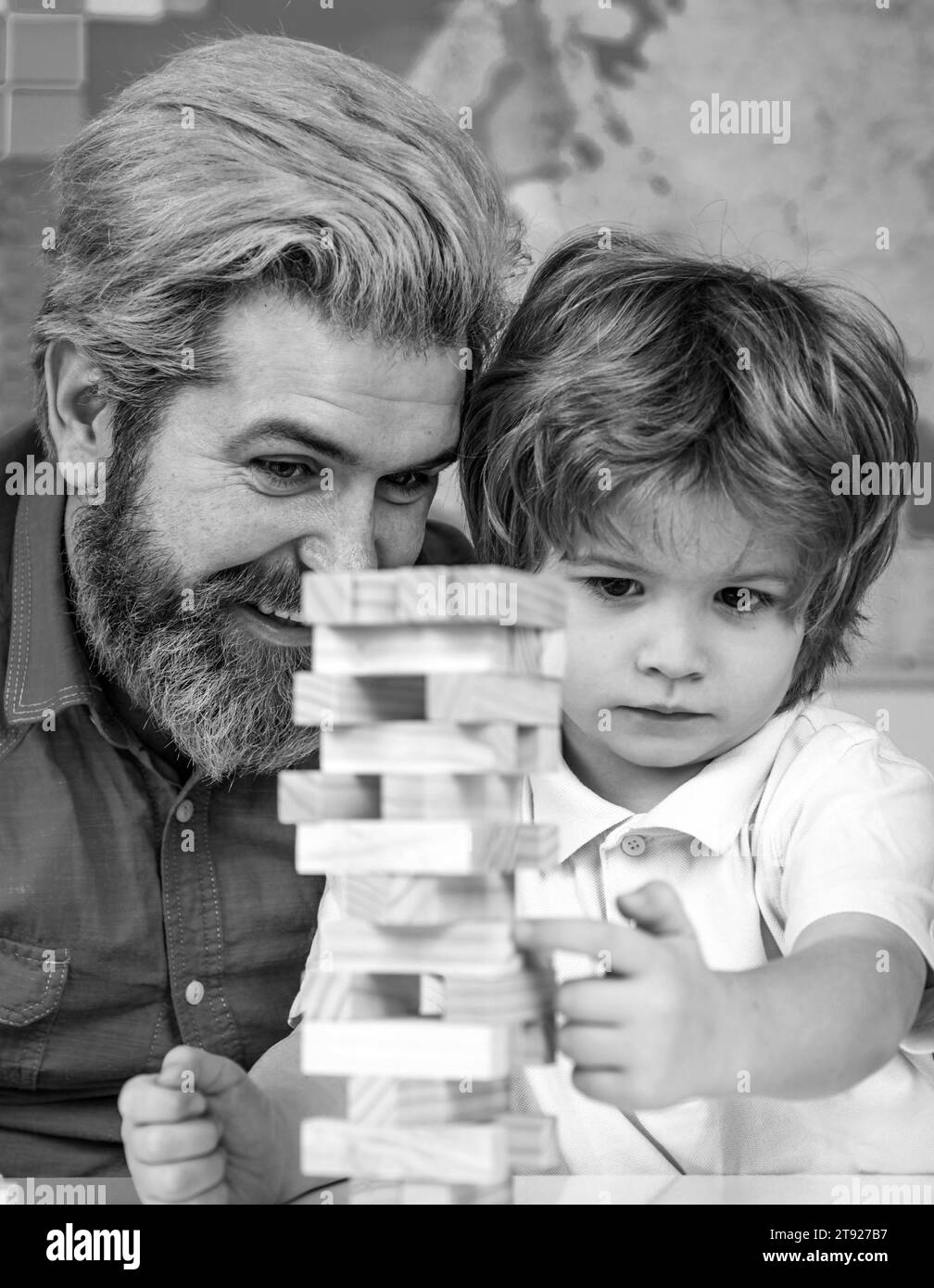 Père et fils jouant des blocs de bois d'empilage Jenga jeux pour la pratique de méditation. Les enfants construisent des blocs de bois à la maison Banque D'Images