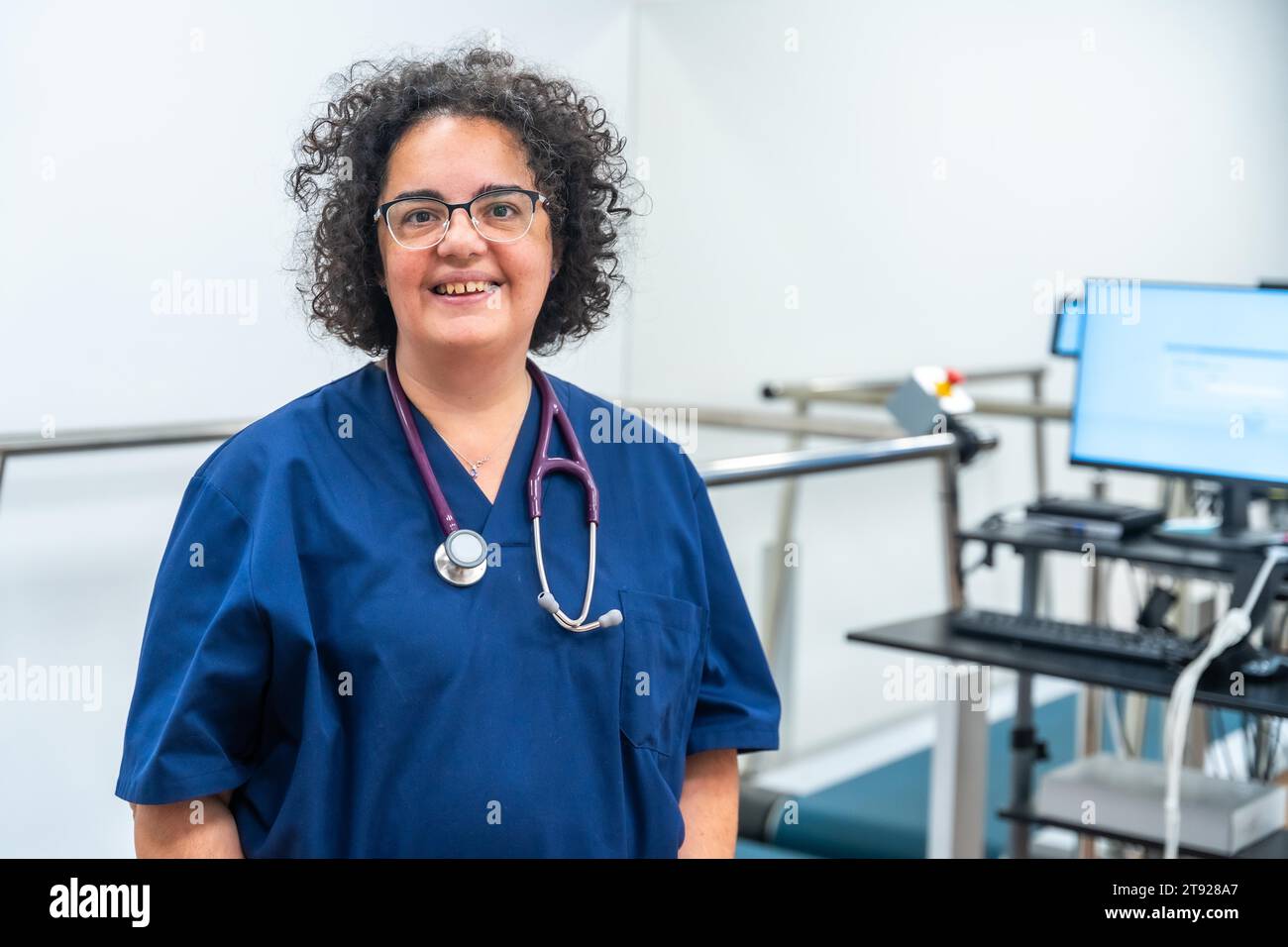 Portrait d'un cardiologue mûr souriant debout fier les bras croisés à l'hôpital Banque D'Images
