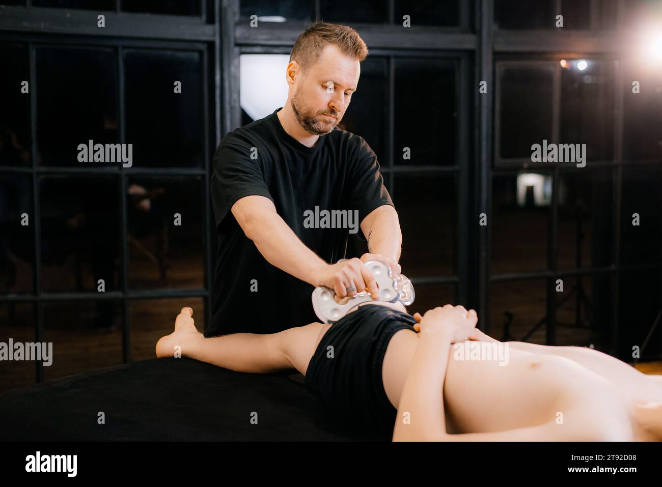 Massage avec une palette de massage spéciale, pétrissage des points de déclenchement dans l'abdomen, gros plan. Massage des lames. Vue latérale. Photo de haute qualité Banque D'Images