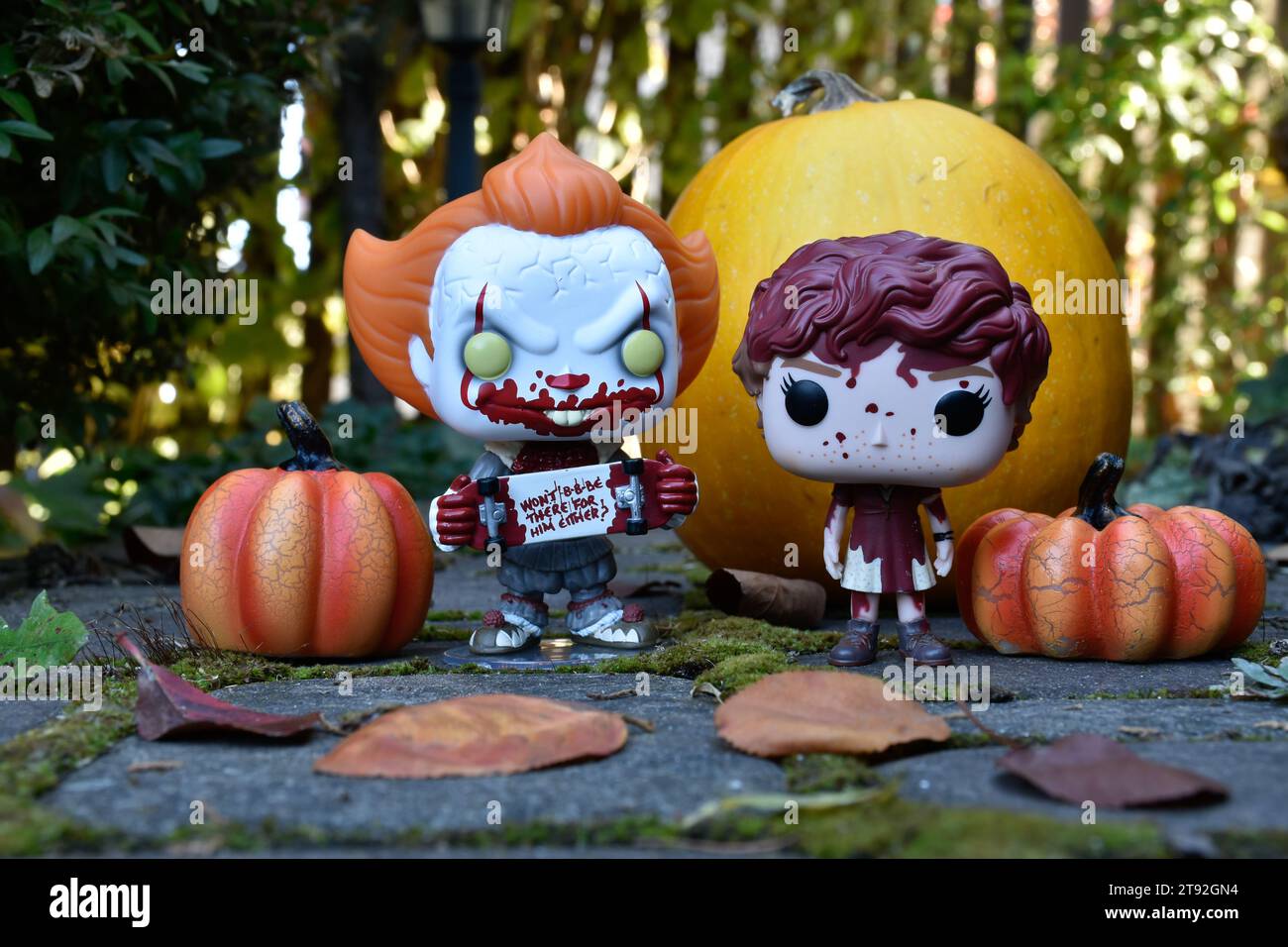 Figurines Funko Pop de Pennywise clown et Beverly Marsh du film d'horreur IT. Halloween, saison effrayante, citrouilles, décor, mousse, feuilles d'automne. Banque D'Images