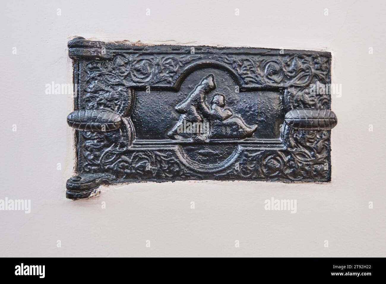 Porte de four en fonte vintage fermée sur mur peint , 19e siècle. L'intrigue est Sledding. Les portes du four sont conçues pour déposer le combustible dans le four, Banque D'Images