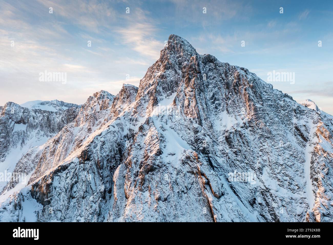 Lumière de lueur tôt le matin sur les montagnes couvertes de neige dans l'arctique de la Norvège, scène panoramique super large. Vue aérienne. Vue panoramique hivernale de la montagne enneigée Banque D'Images
