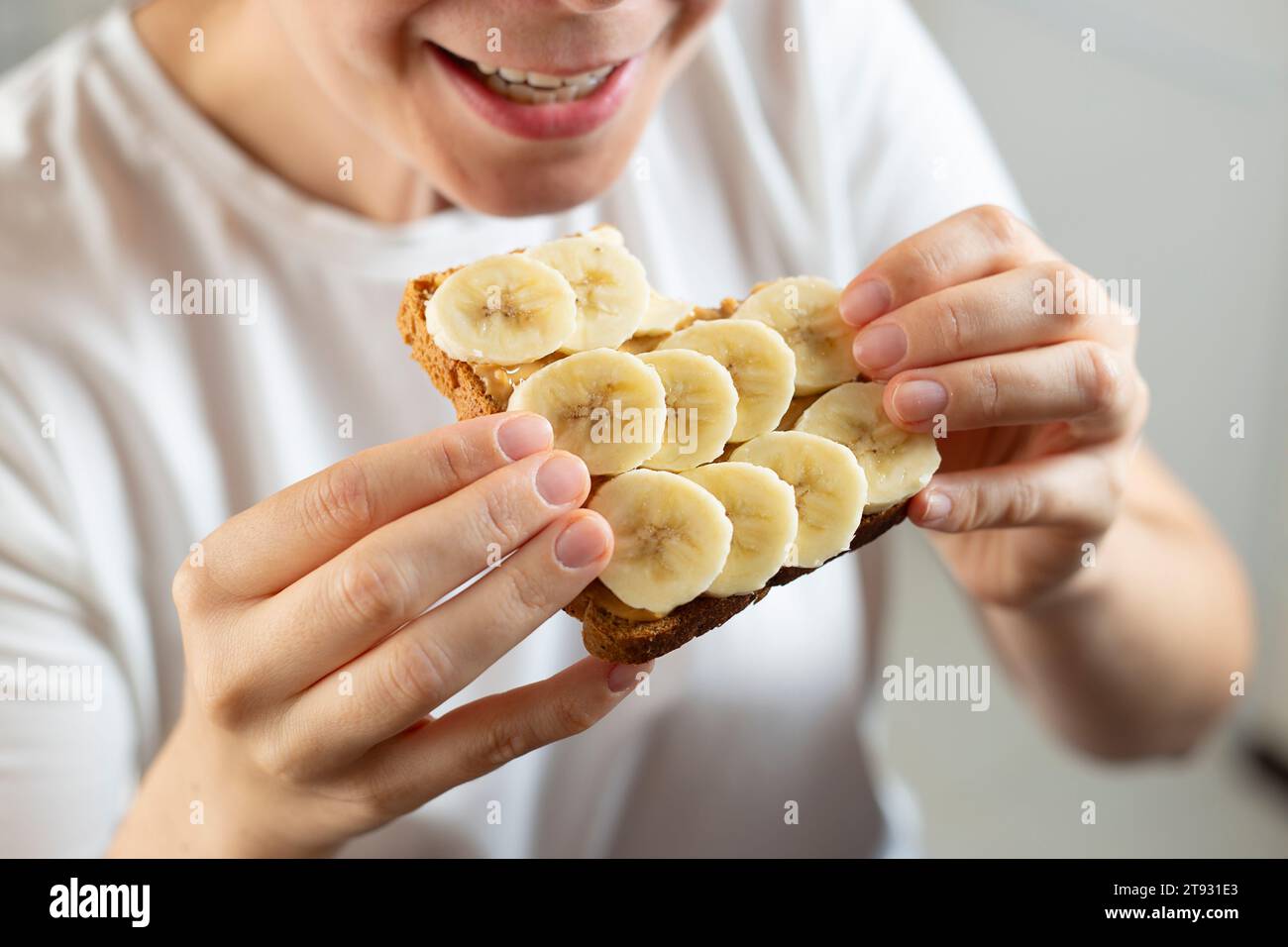 Manger un sandwich avec du beurre de cacahuète et de la banane. Concept de petit déjeuner américain. Banque D'Images