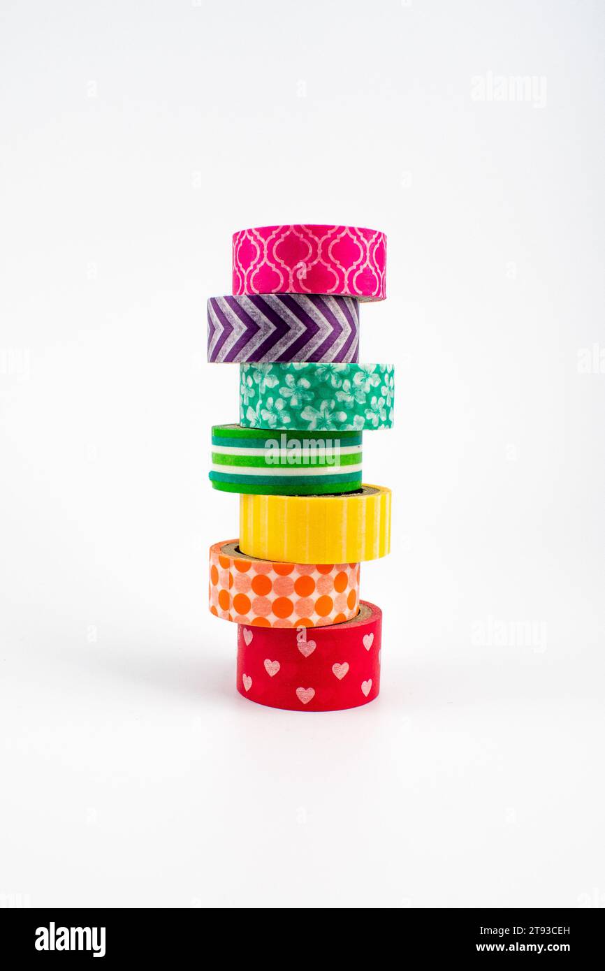 Photo montrant une pile de ruban washi dans des couleurs arc-en-ciel et une variété de motifs Banque D'Images