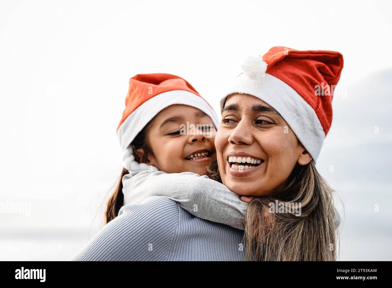 Heureuse Latina mère et fille de l'enfant s'amusant dans le temps de Noël en plein air. Relation amoureuse familiale Banque D'Images