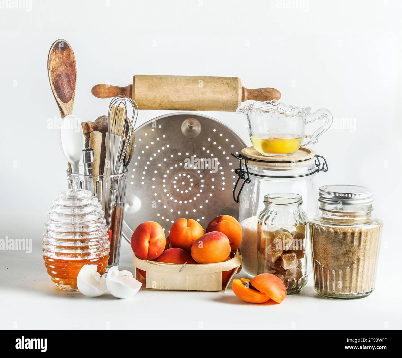 Réglage de cuisson avec abricots, ustensiles de cuisine, outils, miel et ingrédients sur fond blanc. Cuisson avec des fruits de saison à la maison. Vue avant. Banque D'Images