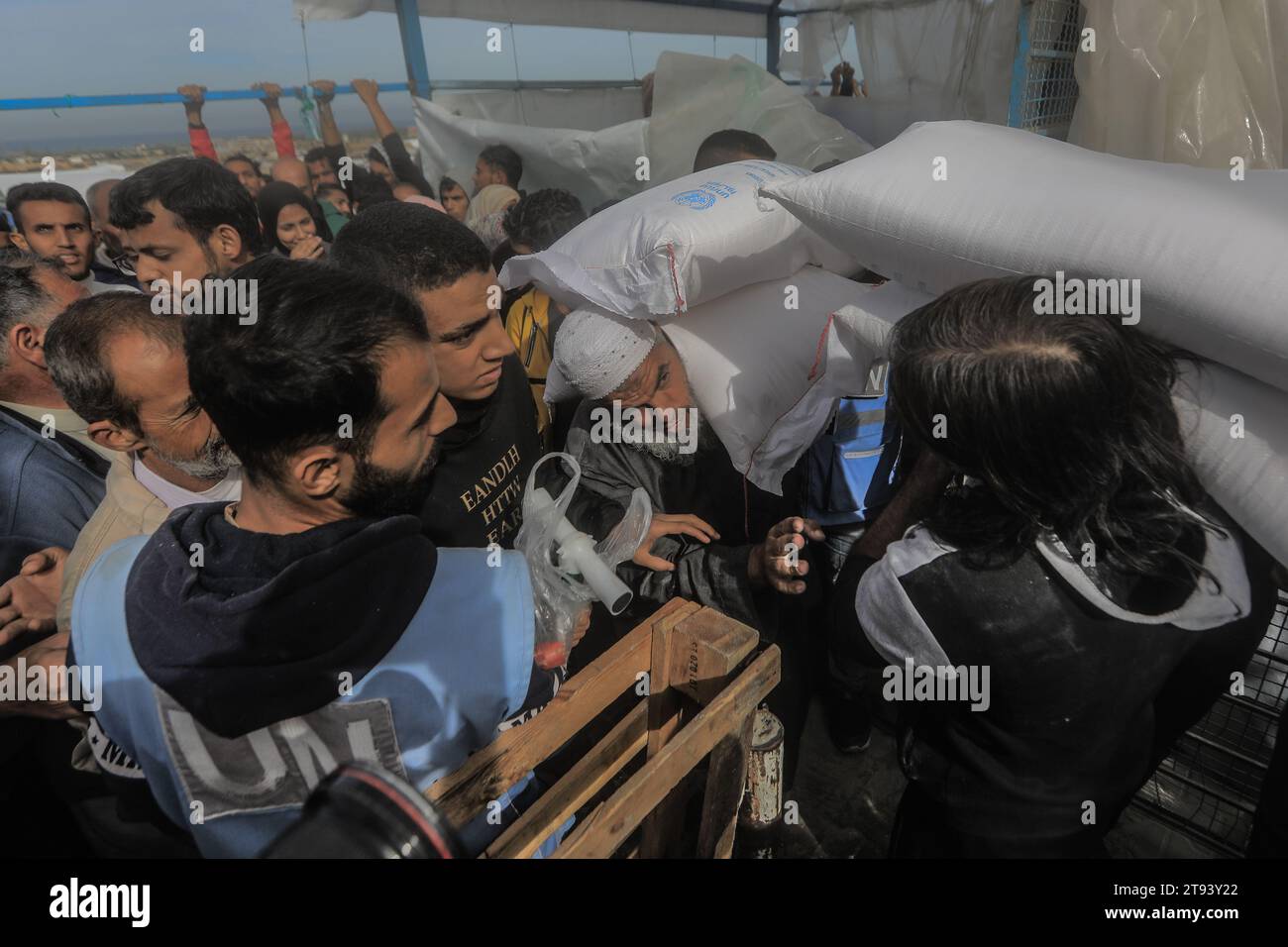 Khan Yunis, Territoires palestiniens. 22 novembre 2023. Les Palestiniens reçoivent des sacs de farine au centre de distribution de l’Office de secours et de travaux des Nations Unies pour les réfugiés palestiniens (UNRWA), dans un contexte de combats en cours entre Israël et le mouvement palestinien Hamas. Crédit : Mohammed Talatene/dpa/Alamy Live News Banque D'Images