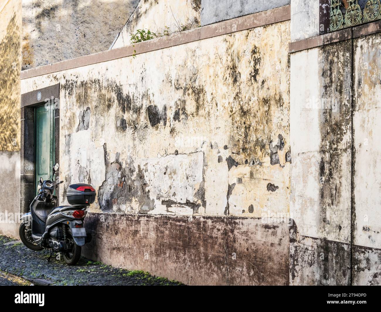 Un scooter Honda SH125 stationné contre un vieux mur. Banque D'Images