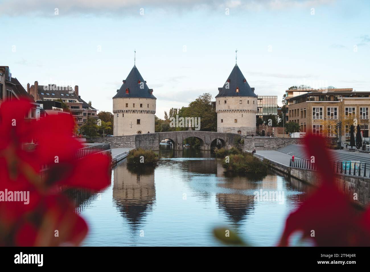 Centre-ville de Kortrijk avec deux tours historiques au bord de la rivière. Fleurs, rivière et bâtiments historiques. Ville belge dans le sud du pays. Banque D'Images