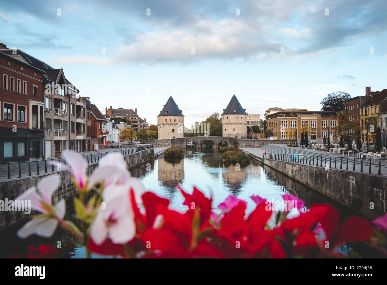 Centre-ville de Kortrijk avec deux tours historiques au bord de la rivière. Fleurs, rivière et bâtiments historiques. Ville belge dans le sud du pays. Banque D'Images