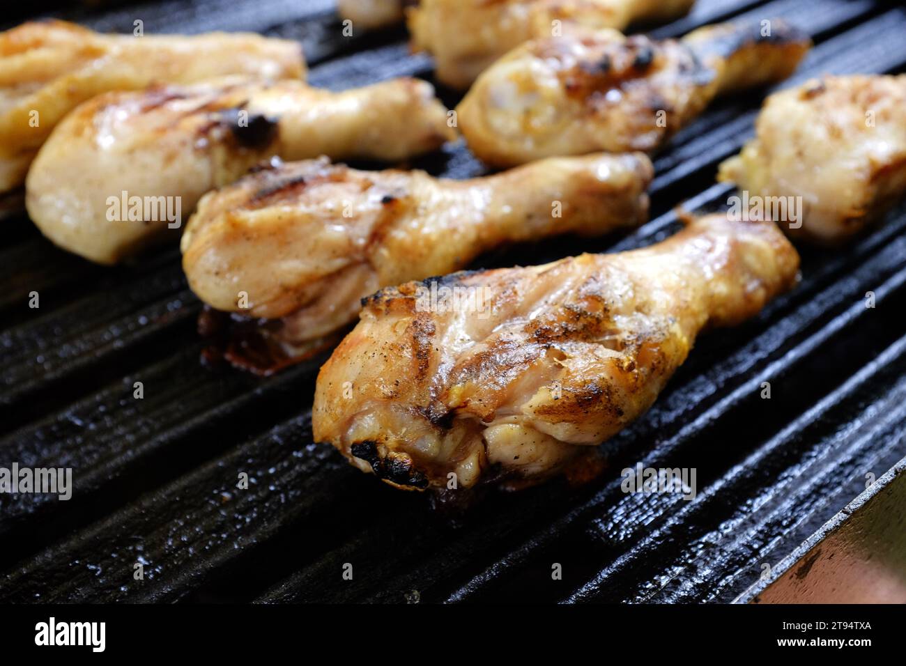 Pilons de poulet grillés sur un barbecue, montrant des marques de grill carbonisées, juteux et bien assaisonnés, parfaits pour les repas en plein air Banque D'Images
