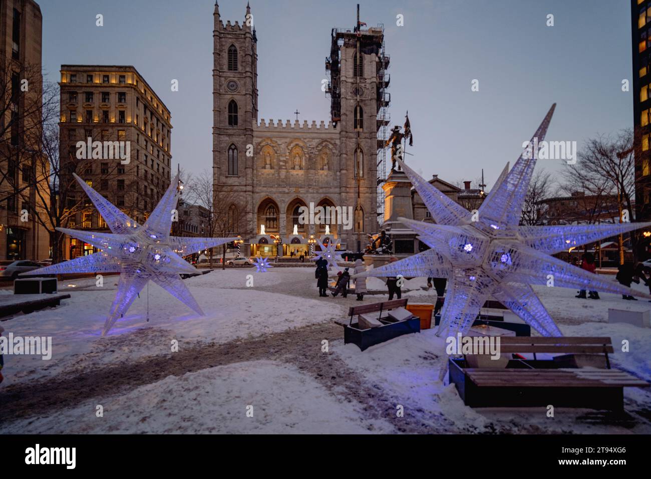 Montréal, Québec, Canada - 26 février 2023 : Basilique notre-Dame prise sur une sombre soirée d'hiver avec des lumières bleues décoratives et quelques méconnaissables Banque D'Images