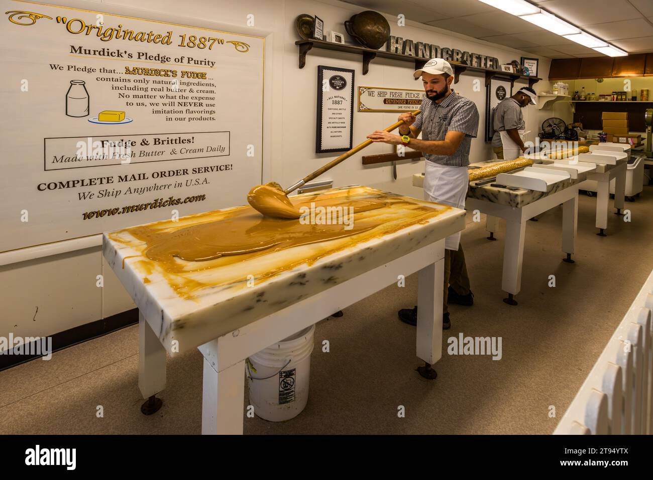 Murdick's Fudge Store Mackinac Island depuis 1887, les Murdicks ont apporté du fudge sur l'île et ils ont été les premiers à faire du fudge sur des dalles de marbre. Aussi comme un spectacle divertissant pour les clients. Aujourd'hui, il y a sept fabricants de fudge sur la petite île. Refroidissement et moulage de caramel sur des dalles de marbre sur l'île Mackinac, où cette spécialité est née depuis le XIXe siècle. Mackinac Island, Michigan, États-Unis Banque D'Images