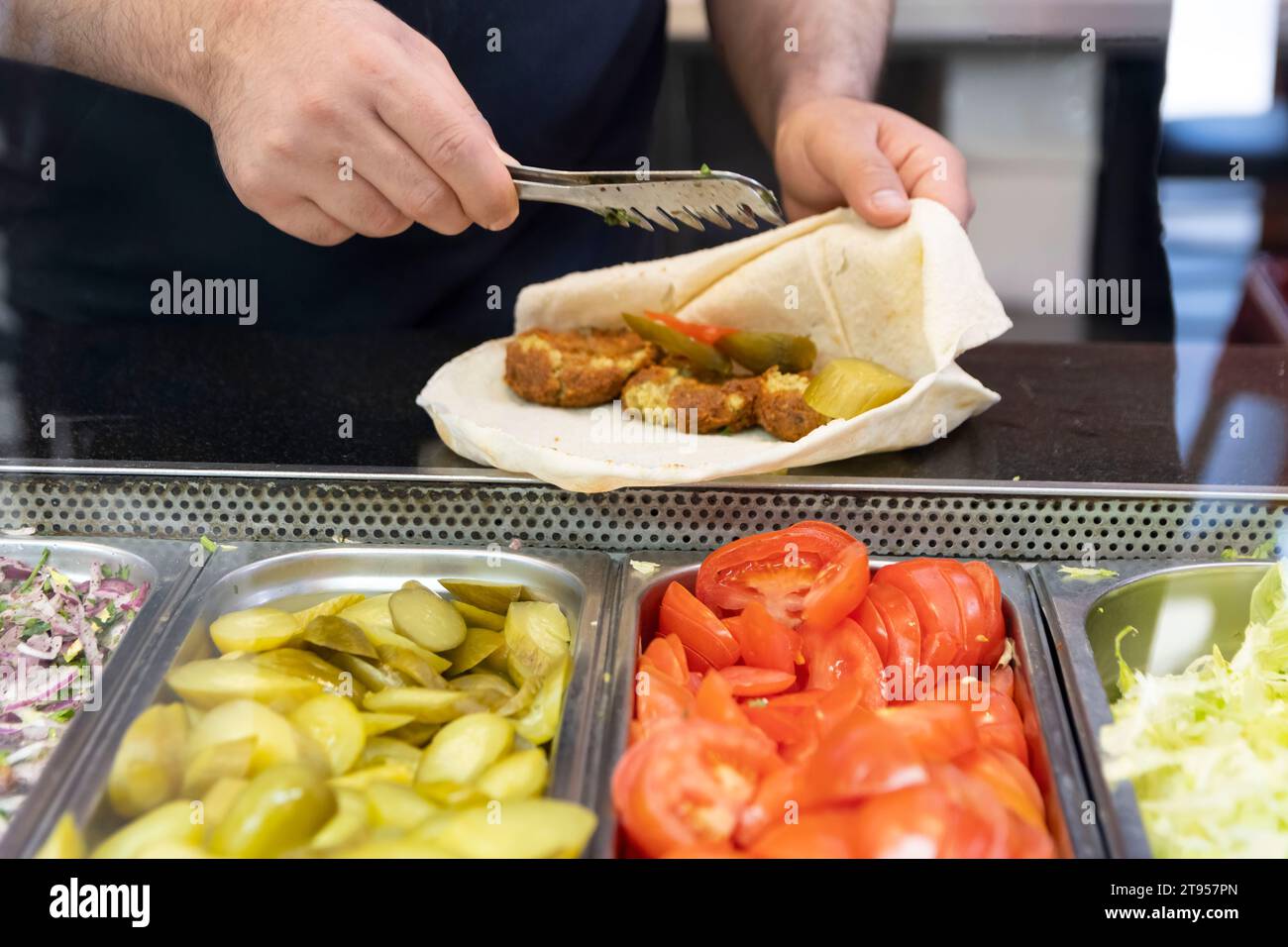 Sandwich falafel pita kebab préparé au comptoir du restaurant. Banque D'Images