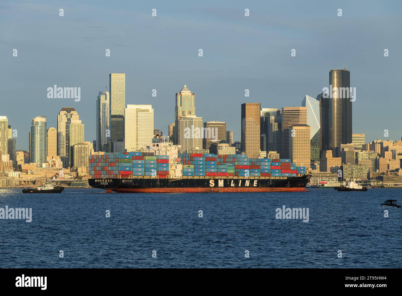 Seattle - 20 novembre 2023 ; navire porte-conteneurs SM Line Qingdao devant Seattle Skyline avec deux remorqueurs Banque D'Images