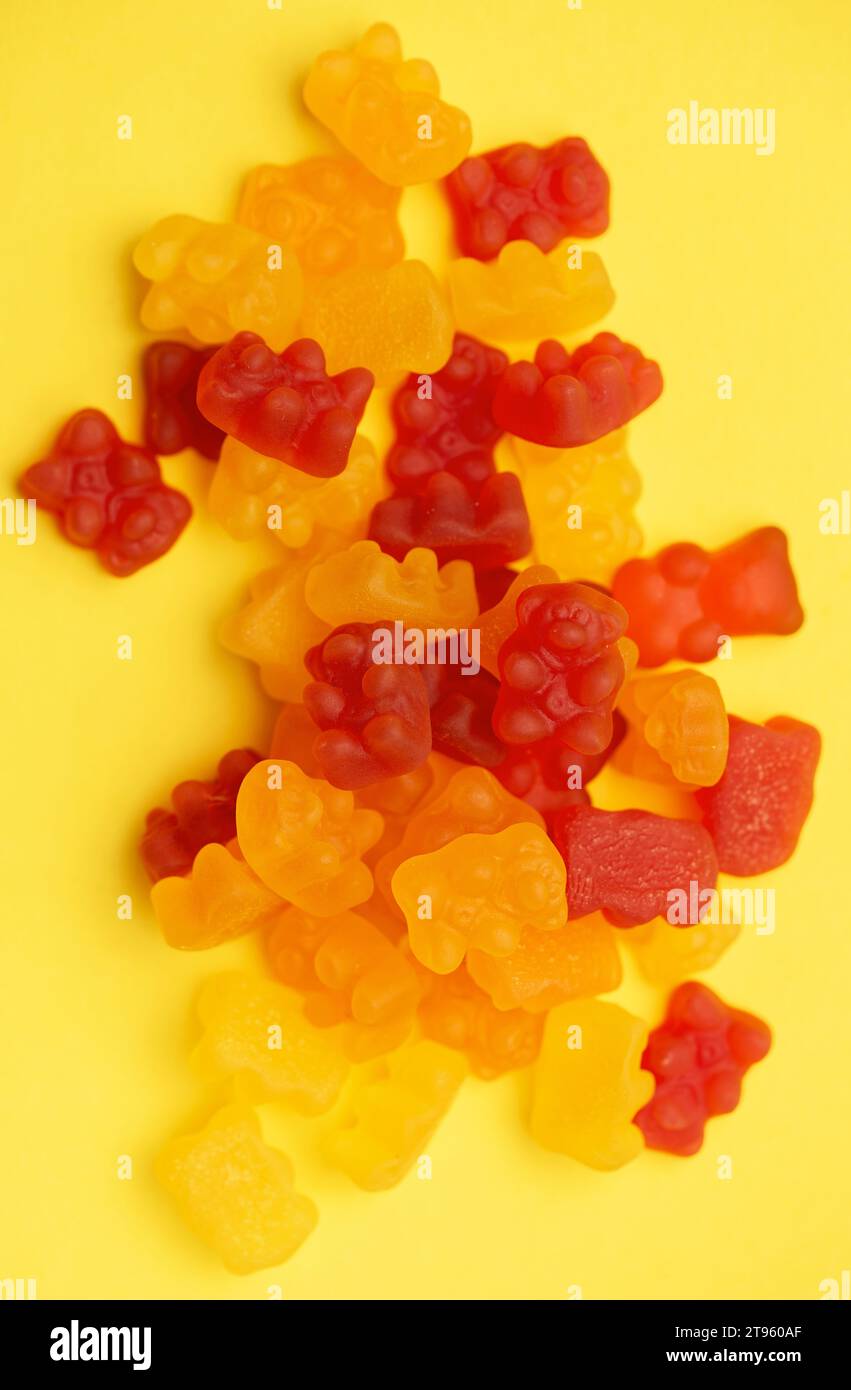 Vitamines pour les enfants, gelée gommeuse porte des bonbons sur fond jaune Banque D'Images