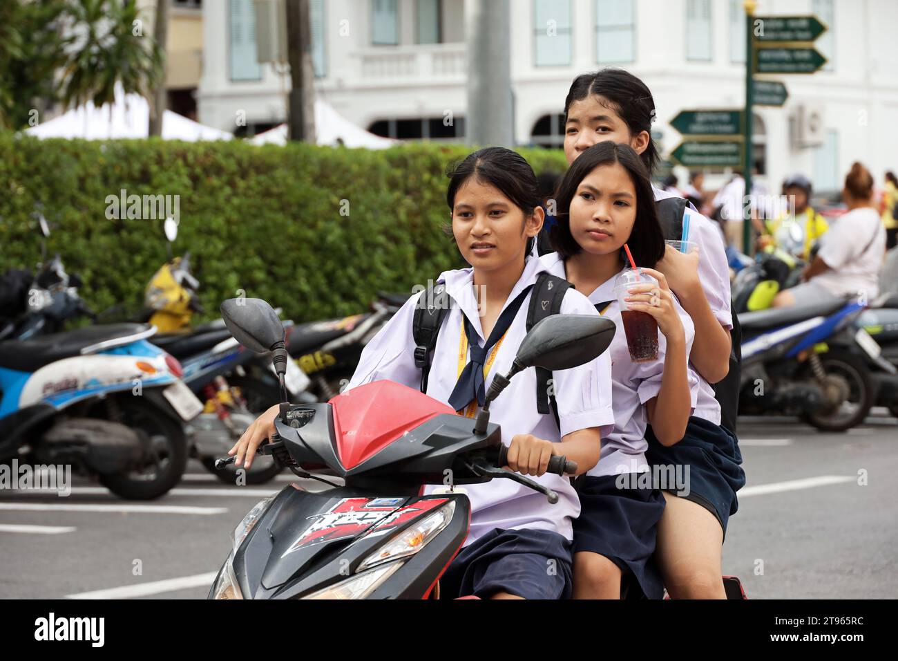 Trois filles thaïlandaises à moto sur la rue de la ville Banque D'Images