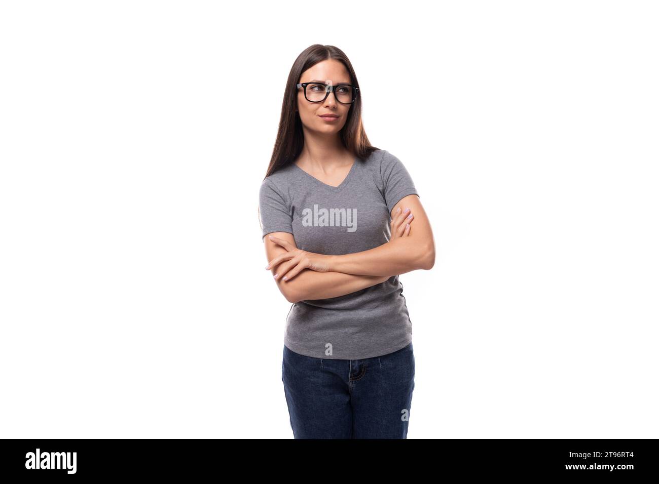 jeune femme européenne brune mignonne vêtue d'un t-shirt de base gris Banque D'Images