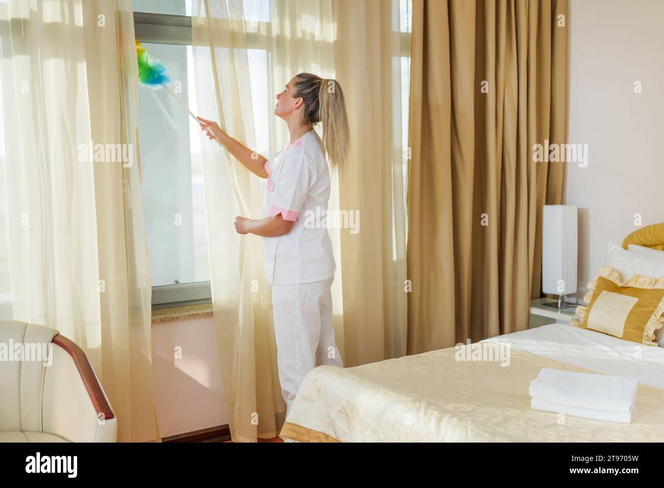 Image de la belle chambre de ménage d'hôtel avec un époussette. Banque D'Images