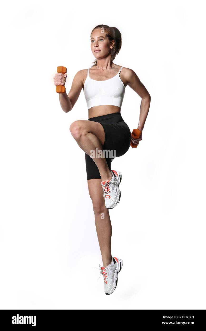 Photo de modèle de fitness s'entraînant avec des haltères sur fond blanc. Sport et mode de vie sain. Banque D'Images