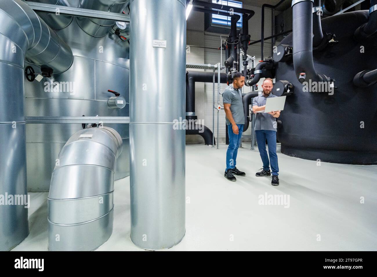 Deux employés utilisant un ordinateur portable dans l'usine Banque D'Images