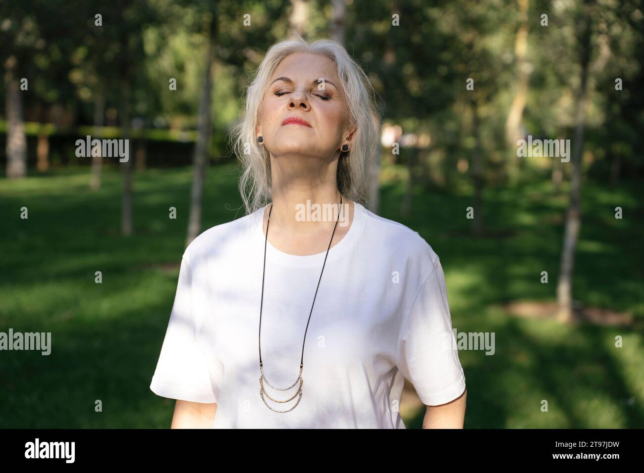 Femme sereine avec les yeux fermés debout dans le parc Banque D'Images