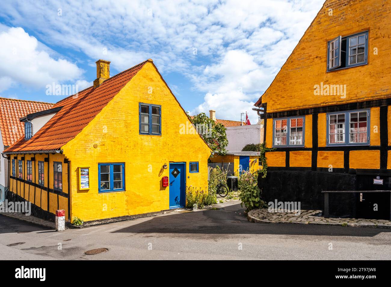 Danemark, Bornholm, Gudhjem, rue vide le long des maisons jaunes Banque D'Images