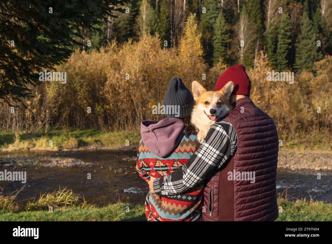 Couple embrassant chien corgi près de la rive dans le parc le week-end Banque D'Images