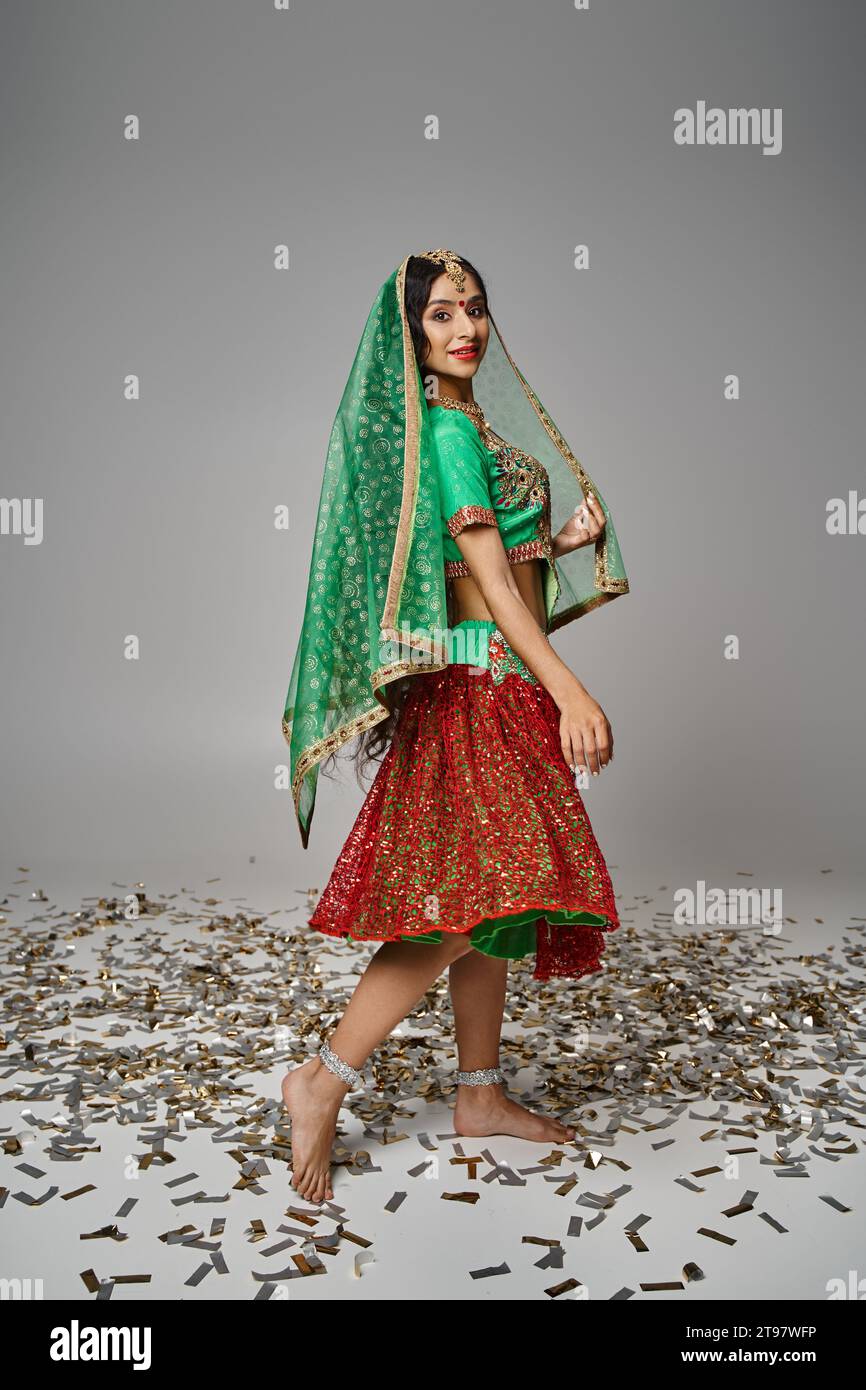 plan vertical d'une jeune femme indienne en vêtements nationaux avec voile et bindi souriant à la caméra Banque D'Images