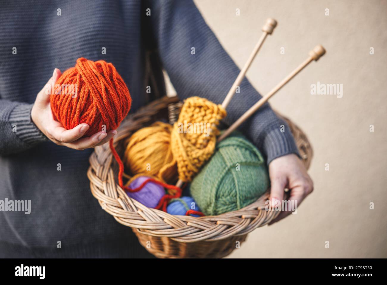 Femme tenant la boule de laine pour tricoter ou crochet. Fil coloré dans le panier en osier Banque D'Images