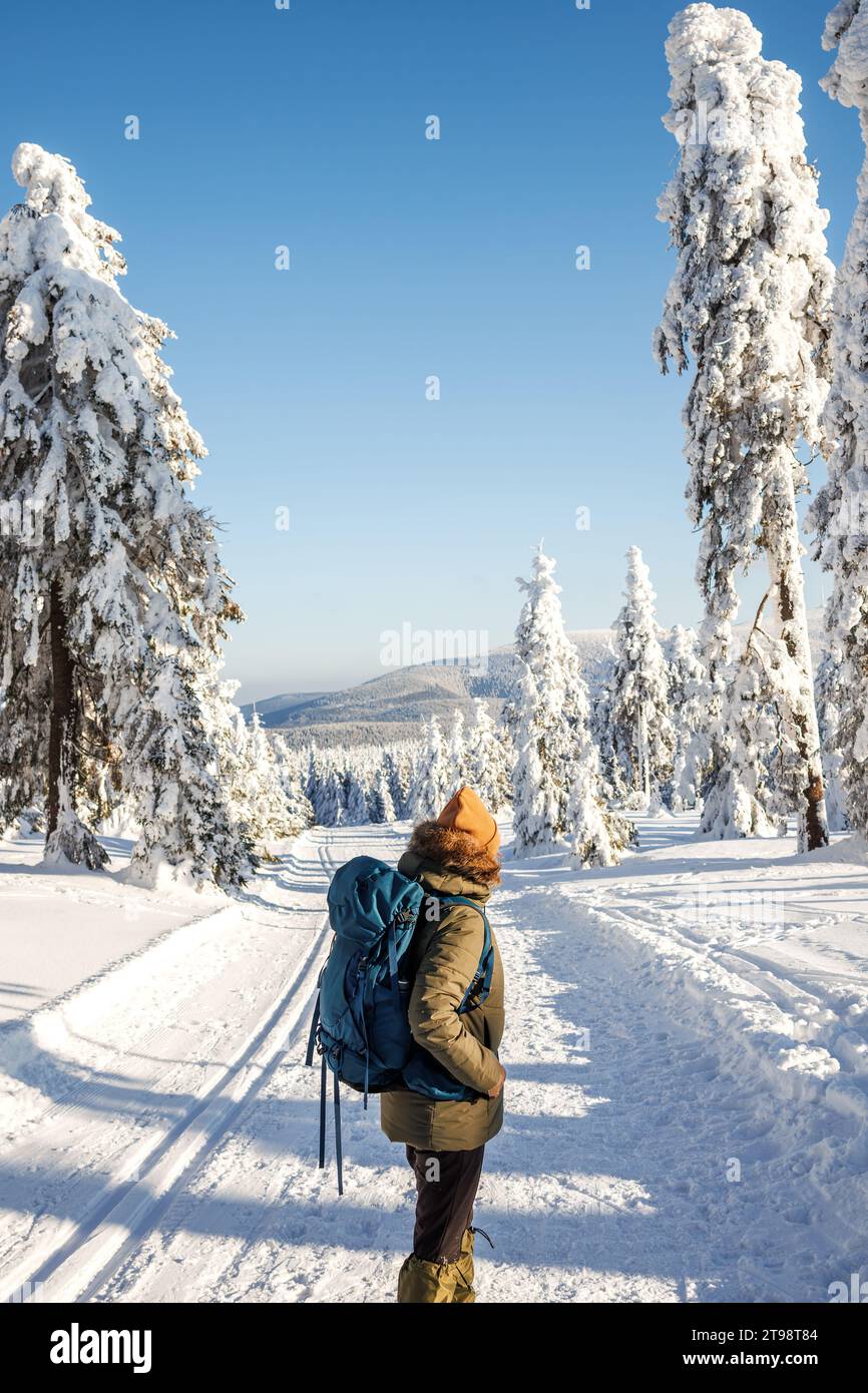 Femme avec sac à dos randonnée dans les montagnes d'hiver au sentier de trekking. Marcher dans la neige dans la nature Banque D'Images