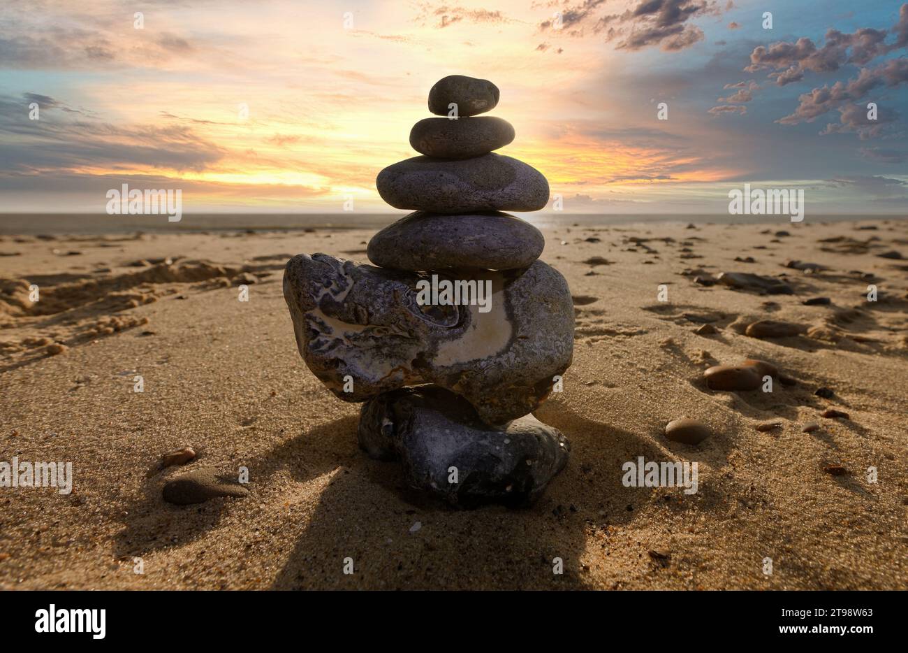 Pierres zen sur une plage avec le lever du soleil Banque D'Images