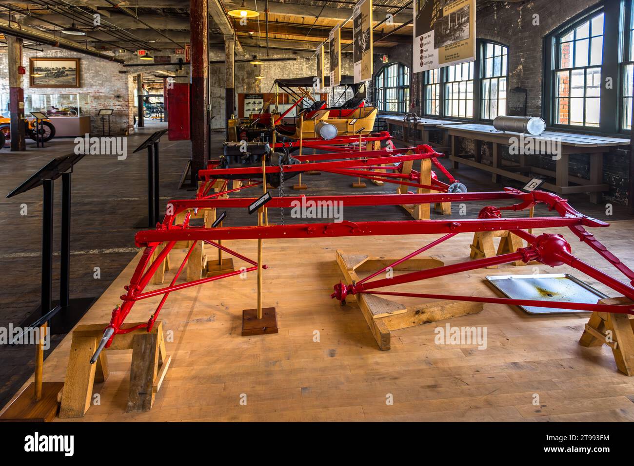 Des châssis rouges vifs sont alignés sur des tréteaux en bois dans la salle d'usine du Ford Piquette Plant à Detroit, Michigan, États-Unis, une reconstitution muséale du processus de chaîne de montage précoce. Construit en 1904, le Ford Piquette Plant est considéré comme le plus ancien bâtiment survivant initialement construit à des fins de production automobile qui reste ouvert au public. Banque D'Images