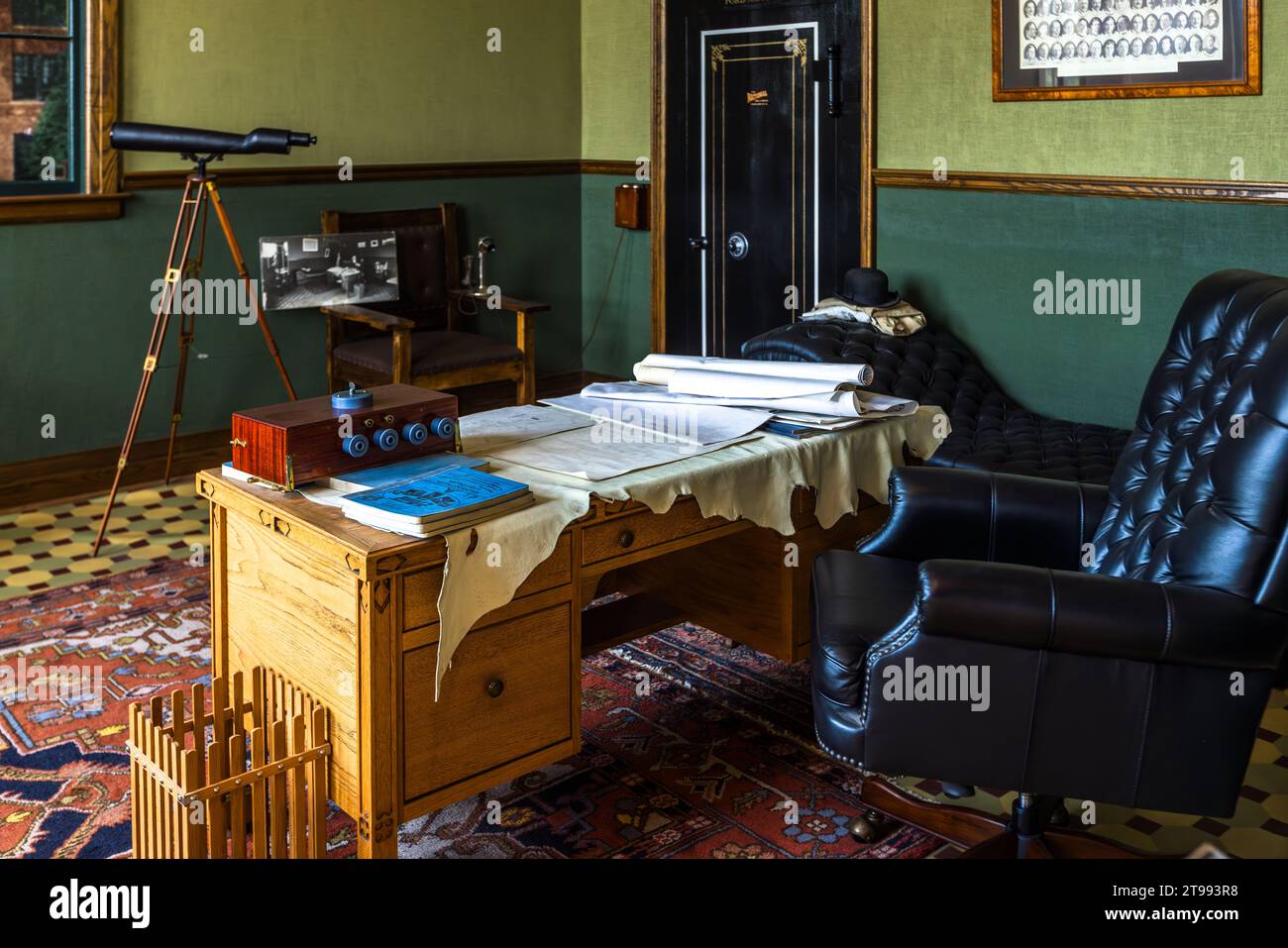 Un télescope sur un trépied, un bureau à enrouleur recouvert de plans et un coffre-fort mural noir se dressent dans le bureau recréé d’Henry Ford dans la salle de l’usine du Ford Piquette Plant à Detroit, Michigan, États-Unis. Construit en 1904, le Ford Piquette Plant est considéré comme le plus ancien bâtiment survivant initialement construit à des fins de production automobile et encore ouvert au public. Banque D'Images