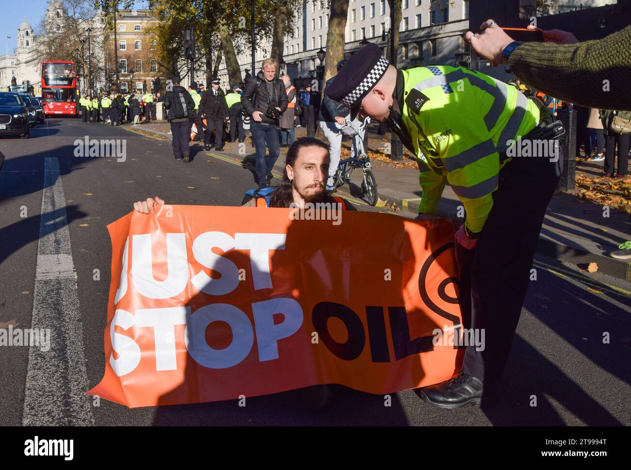 Londres, Royaume-Uni. 23 novembre 2023. Des militants de Just Stop Oil sont arrêtés par des policiers de la Metropolitan police à Whitehall, près de Downing Street. Le groupe d'action pour le climat a marché de Trafalgar Square sur le trottoir et a été arrêté quelques secondes après avoir marché sur la route le quatrième jour consécutif alors qu'ils poursuivaient leurs protestations contre les nouvelles licences de combustibles fossiles. Crédit : Vuk Valcic/Alamy Live News Banque D'Images