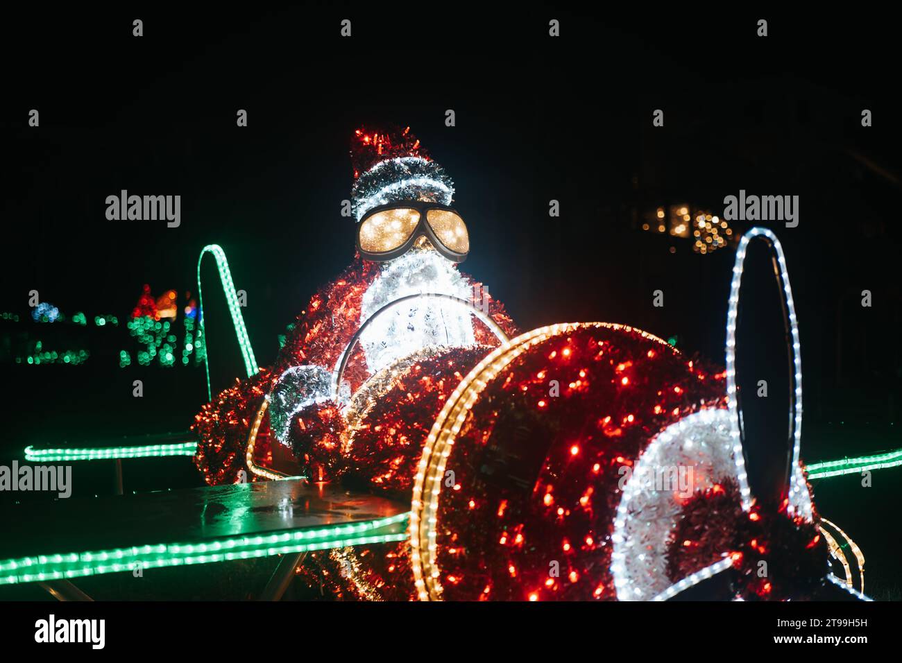 Figurines de Noël brillantes. Père Noël sur une installation lumineuse d'hélicoptère. Décor de rue de Noël en guirlandes Banque D'Images