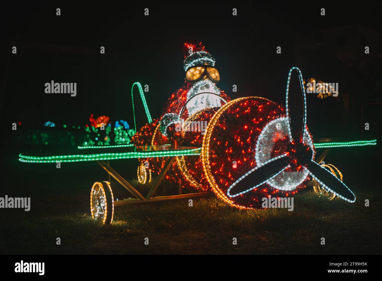 Père Noël sur un hélicoptère . Décor de rue de Noël en guirlandes. Figurines de Noël éclatantes Banque D'Images