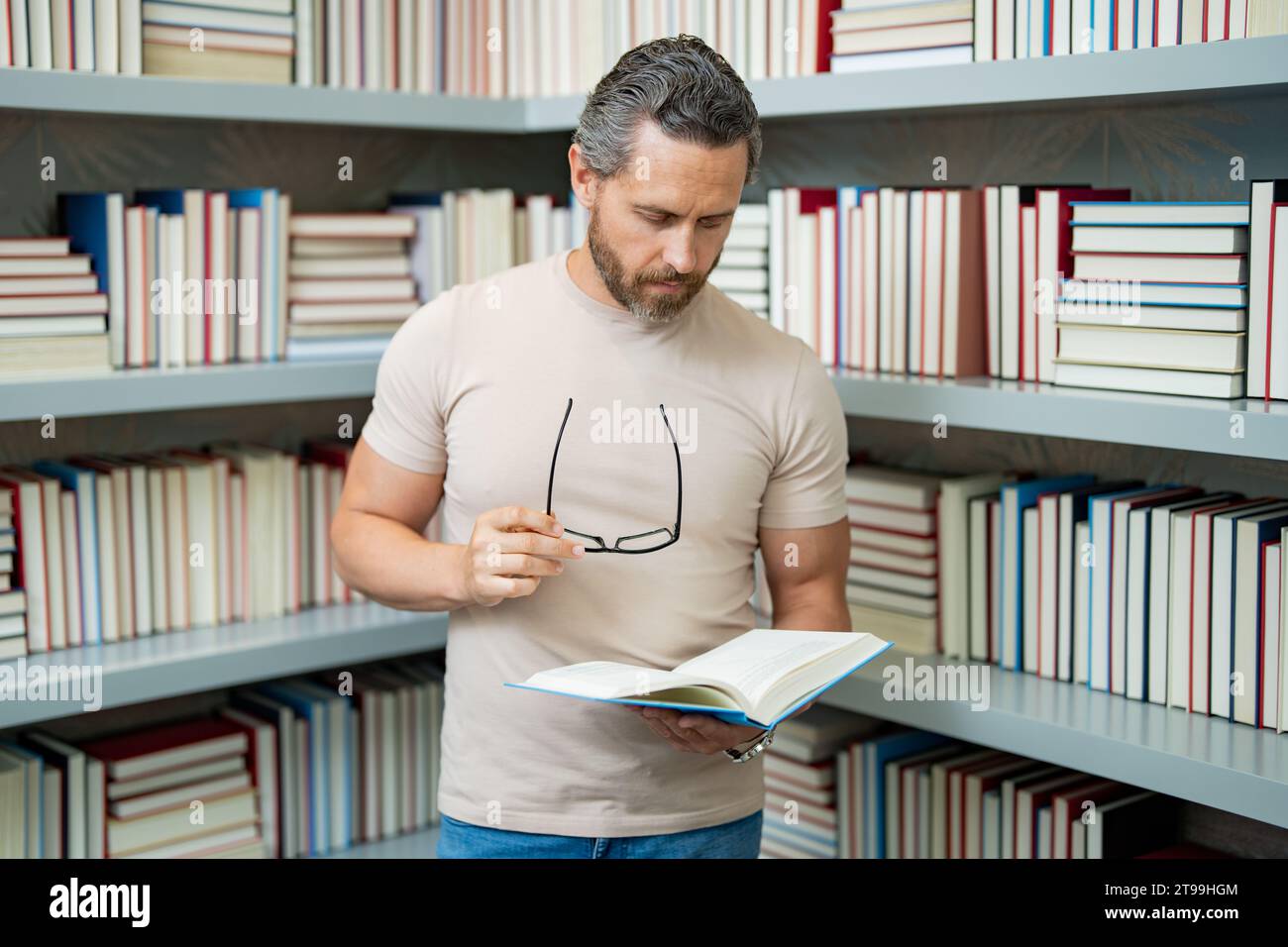 Portrait de professeur d'école avec livre dans la salle de classe. Beau professeur en classe. Journée des enseignants. Bon professeur. Tuteur en classe. Homme enseignant avec Banque D'Images
