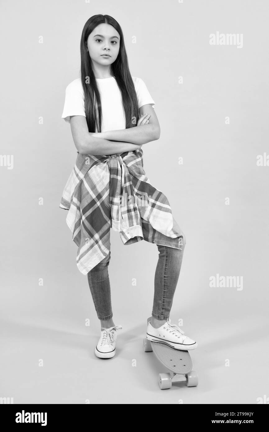 Mode de vie adolescent, belle jeune fille avec planche à roulettes isolée sur fond de studio. Banque D'Images