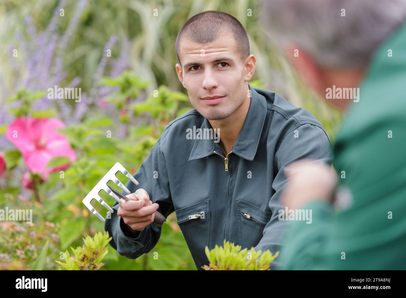 Homme de flou artistique le ratissage des feuilles au jardin Banque D'Images