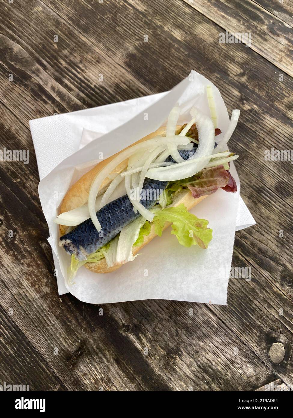 Rouleau de hareng Bismarck, rouleau de hareng avec hareng Bismarck, hareng, oignons, salade, se trouve dans une serviette sur une table en bois, île de la mer du Nord Sylt, mer du Nord Banque D'Images