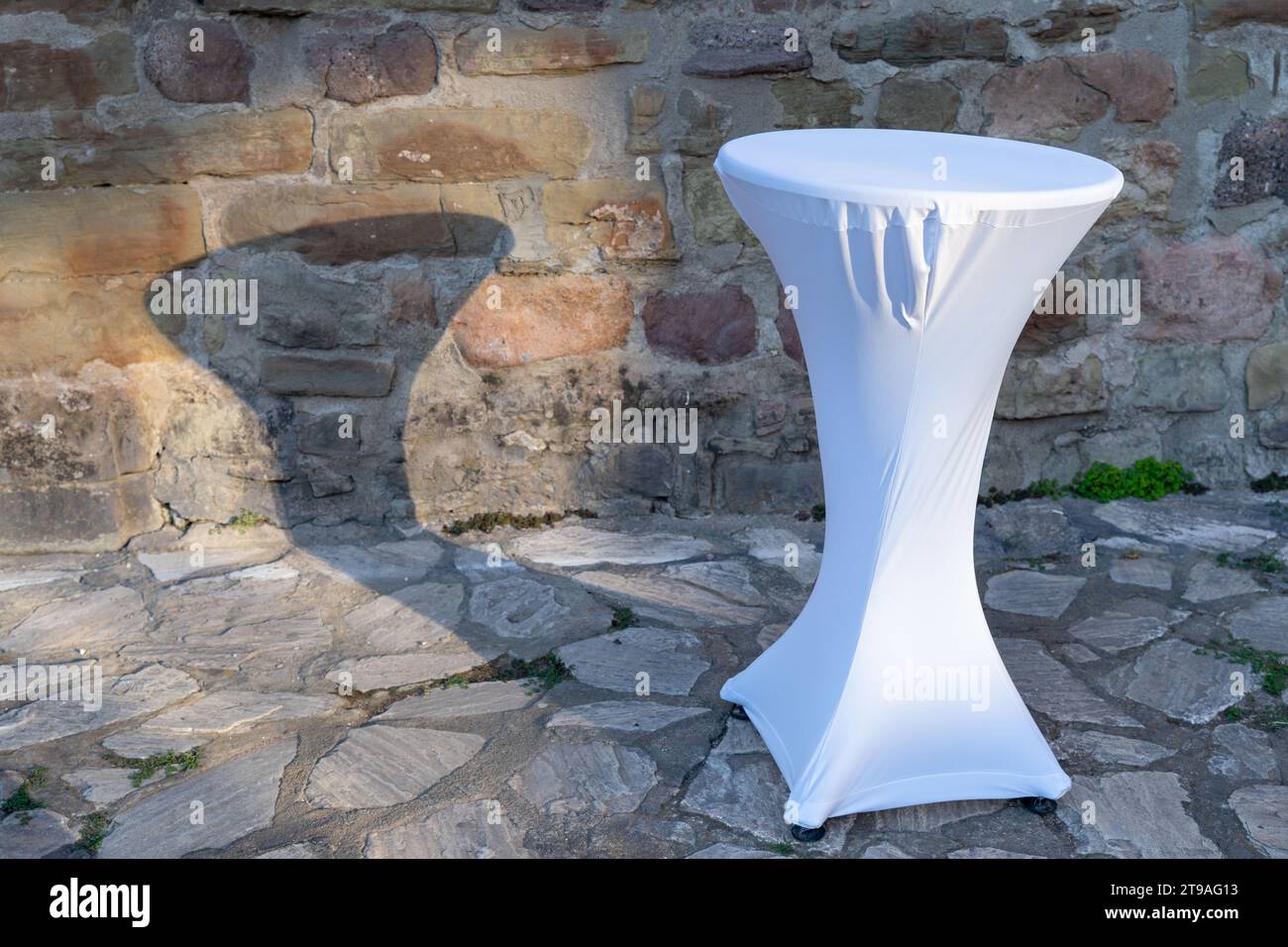 Décoration de table de drap blanc , pour événement spécial, occasion. Ombre de lumière du soleil sur le mur. Contexte Banque D'Images