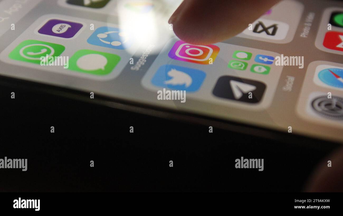 Appuyer sur l'icône Instagram avec le doigt, interaction de l'écran de smartphone Banque D'Images
