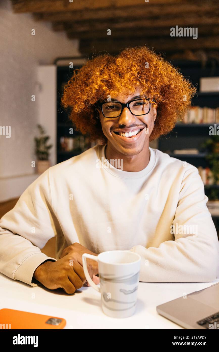 Portrait d'un jeune homme afro-américain souriant avec coiffure afro dans un salon. Heureux jeune homme dans un salon. Banque D'Images