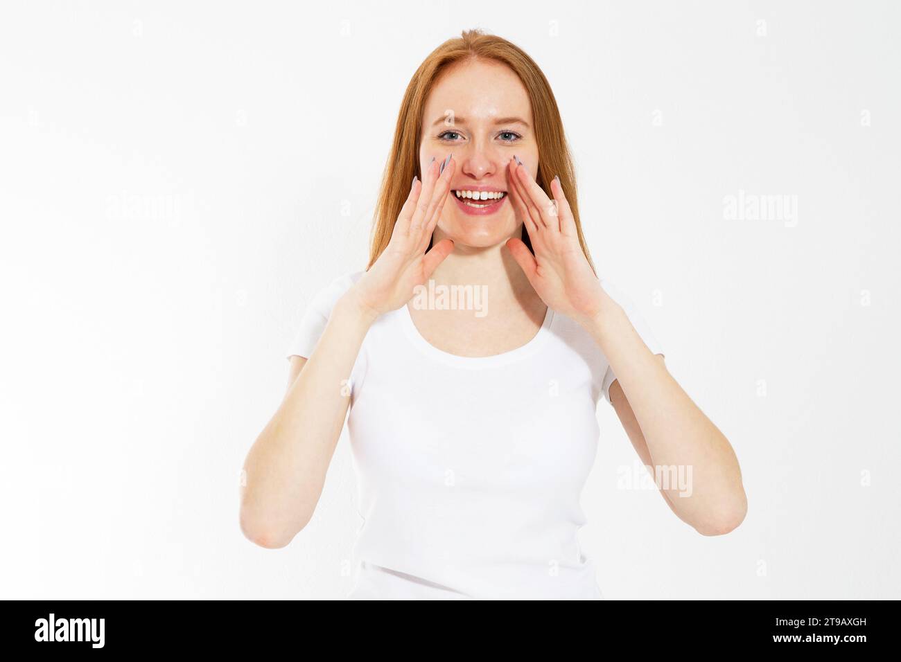 Jeune femme racontant quelque chose, fille à tête rouge racontant un secret. Portrait jeune femme heureuse qui appelle à quelqu'un. Drôle de modèle de fille chuchotant sur Banque D'Images