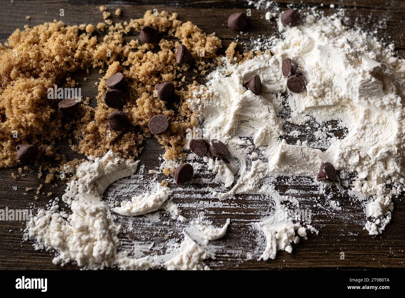 gros plan de sucre, de farine et de pépites de chocolat sur une surface en bois Banque D'Images