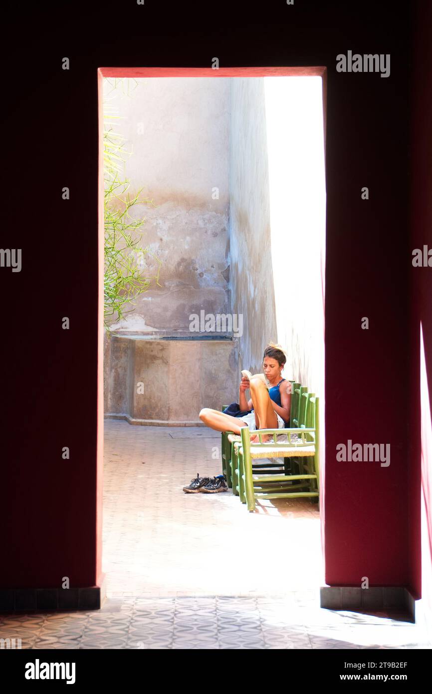 Fille lisant livre à l'ombre des palmiers au Maroc Banque D'Images