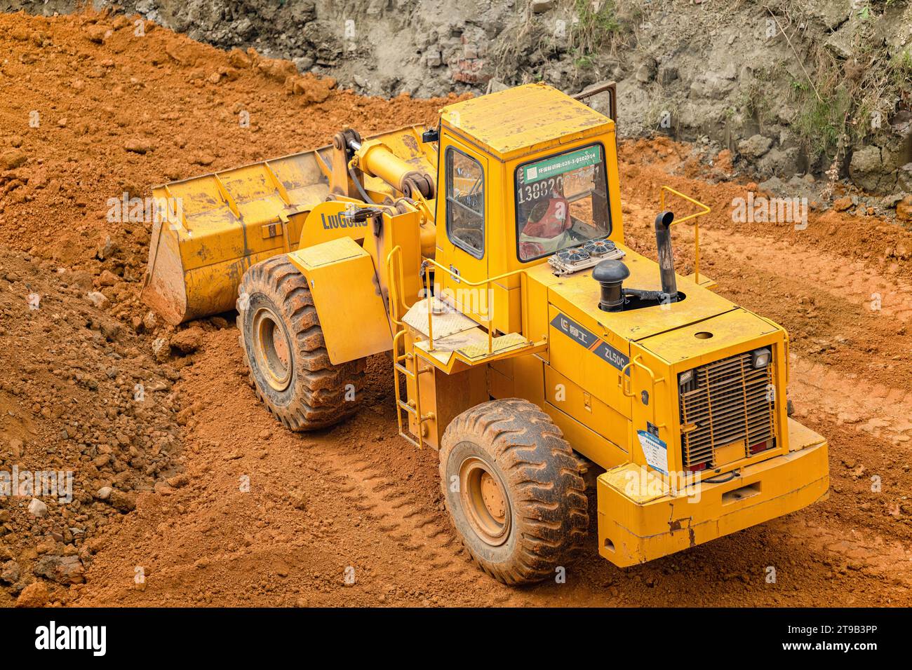 Excavatrice creusant le sol sur le chantier. Banque D'Images